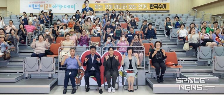 최충규 대덕구청장, 권동호 수어통역사, 그리고 지역 주민들이 강연을 마친 후 기념사진을 촬영하고 있다.