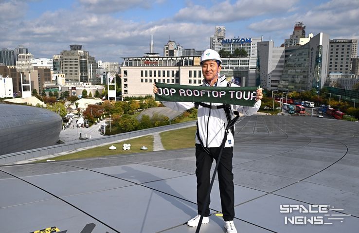 오세훈 서울시장이 23일 열린 ‘DDP 루프탑 투어’에 참석해 알루미늄 패널로 된 DDP 지붕 위에서 기념수건을 들어 보이고 있다.