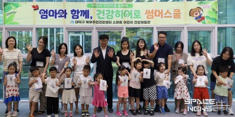 최충규 대덕구청장(사진 두 번째 줄 왼쪽 다섯 번째)과 ‘엄마와 함께 건강히어로 썸머스쿨’에 참여한 가족들이 기념촬영을 하고 있다.