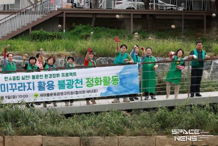 불광천에 흙 공을 던지고 있는 새마을운동 은평지구회와 김미경 구청장(오른쪽 두 번째)