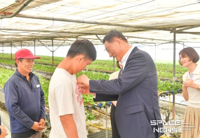 7월 김한종 장성군수가 외국인 계절근로자에게 한글 이름 명찰을 달아주고 있다.