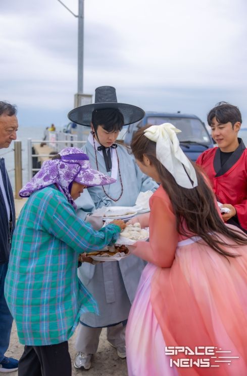 여행 참가자들이 섬 어르신들께 직접 만든 송편과 간식을 나눠드리고 있다