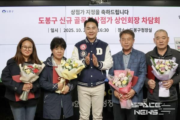 오언석 도봉구청장(가운데)과 이번에 새로 신규 지정된 골목형상점가 상인회장이 신규 지정을 기념하며 단체 사진을 찍고 있다