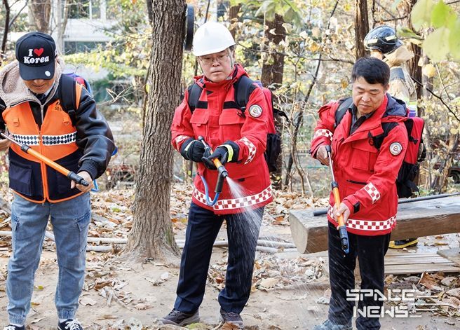 진교훈 서울 강서구청장(가운데)이 21일 오후 우장산 일대에서 열린 ‘유관기관 합동 산불진압훈련’에서 등짐펌프를 매고 산불진화대원과 함께 잔불진화작업을 하고 있다.